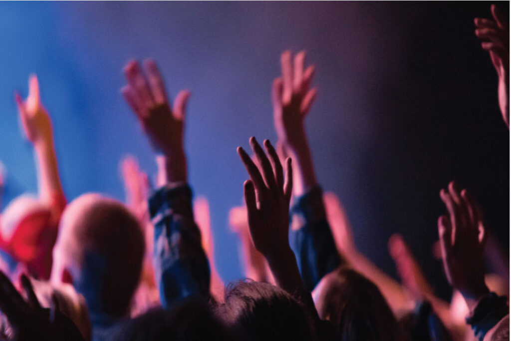 people worshiping with hands raised in the air